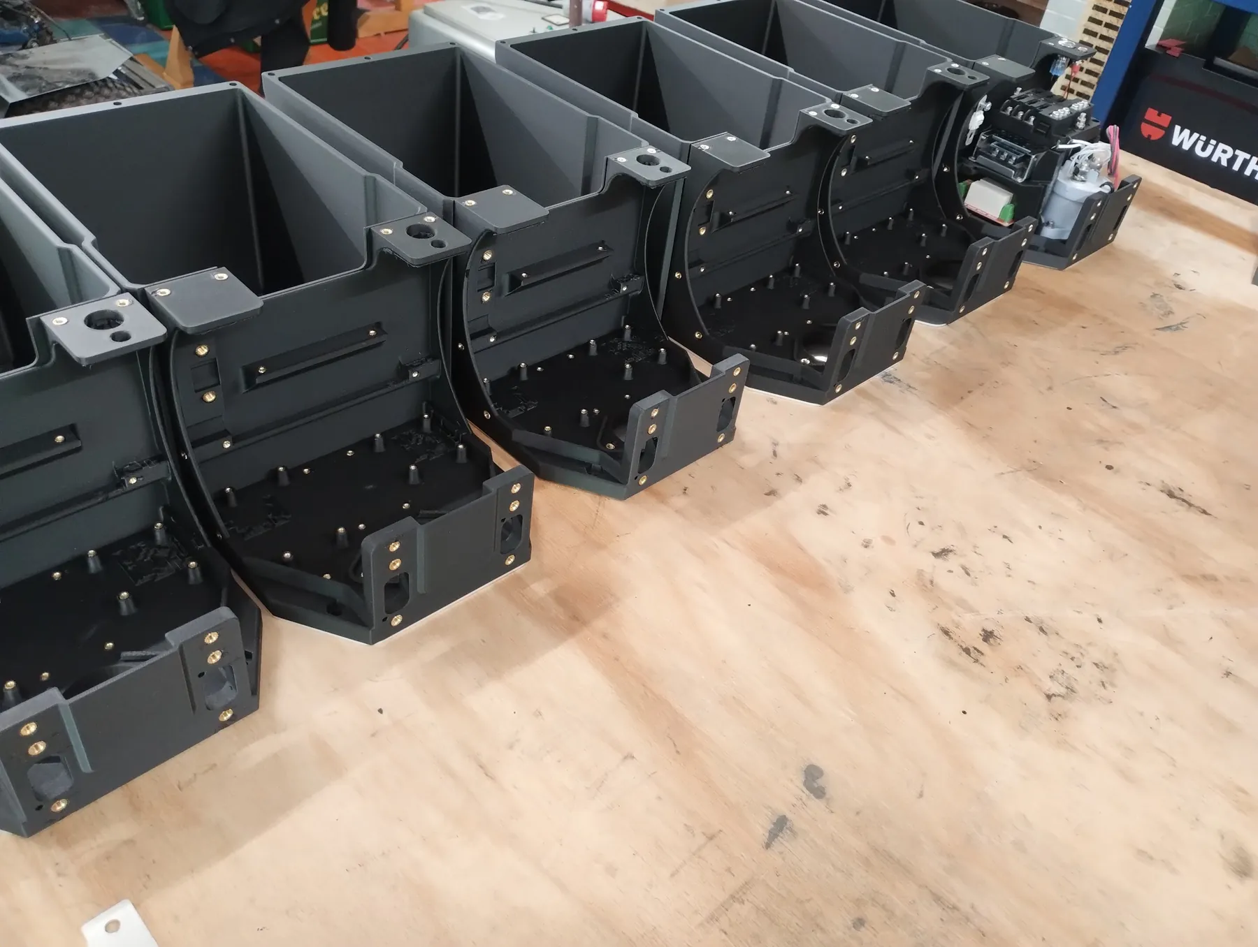 A row of printed battery cases on a workbench